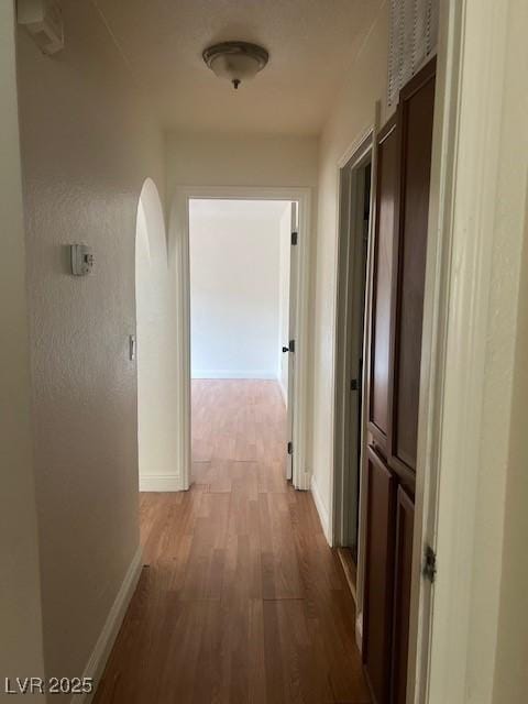 hallway with baseboards and wood finished floors