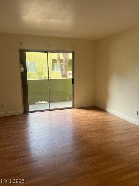 empty room featuring wood finished floors and baseboards