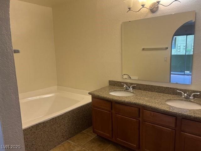 full bath featuring tile patterned floors, a garden tub, a sink, and double vanity