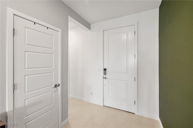 hall with light tile patterned flooring and baseboards