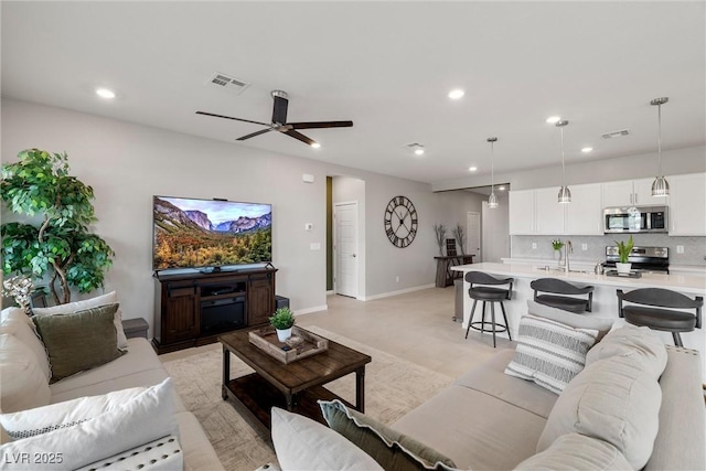 living area featuring baseboards, visible vents, and recessed lighting