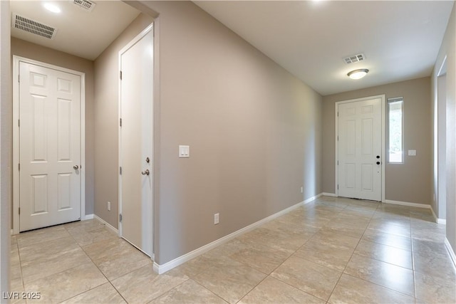 foyer featuring baseboards, visible vents, and light tile patterned flooring