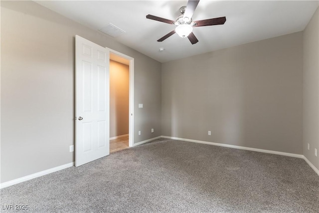 empty room with carpet floors, visible vents, baseboards, and a ceiling fan