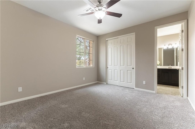 unfurnished bedroom featuring ensuite bathroom, light colored carpet, visible vents, baseboards, and a closet