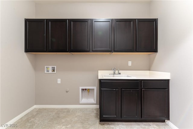 laundry area featuring gas dryer hookup, washer hookup, a sink, baseboards, and cabinet space