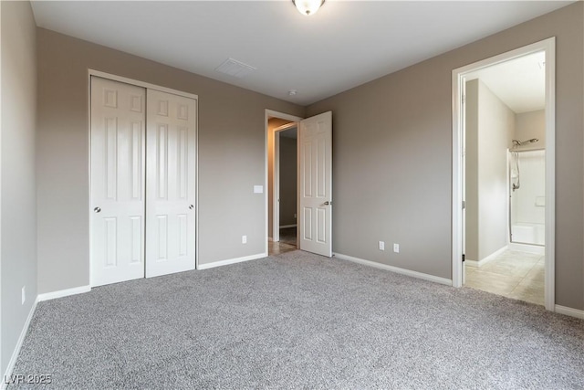 unfurnished bedroom with a closet, carpet flooring, and baseboards