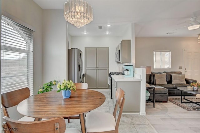 dining room featuring an inviting chandelier, plenty of natural light, light tile patterned floors, and visible vents