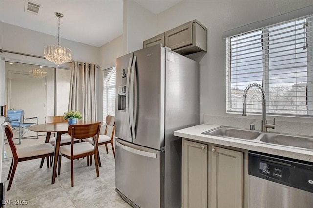 kitchen with appliances with stainless steel finishes, gray cabinets, light countertops, and a sink