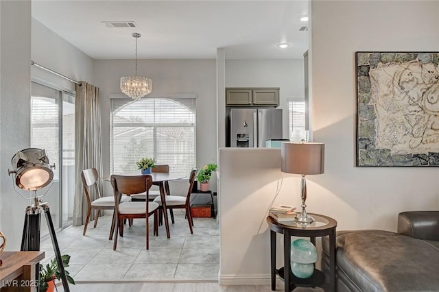 dining area featuring a healthy amount of sunlight, visible vents, a chandelier, and light tile patterned flooring