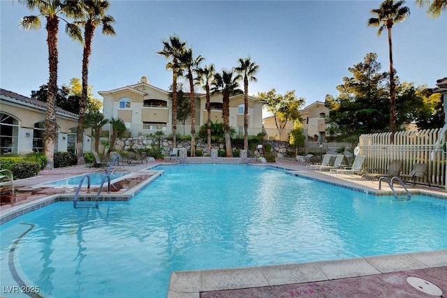 community pool with a patio area, a residential view, and fence