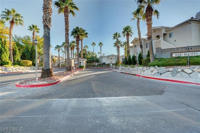 view of street with a residential view, a gated entry, and curbs