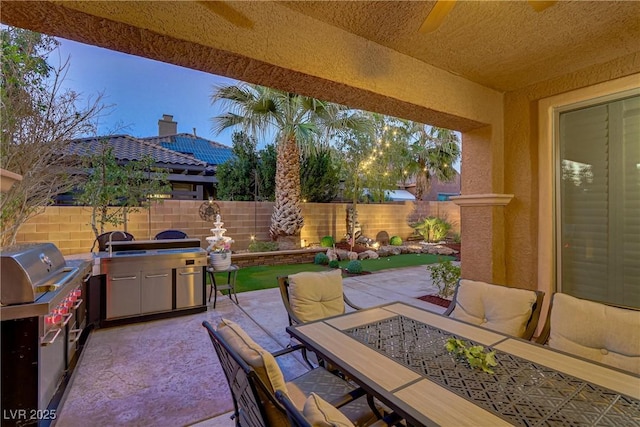 view of patio featuring outdoor dining space, area for grilling, and a fenced backyard