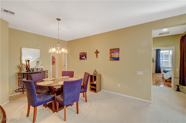 dining space with light carpet, visible vents, and baseboards