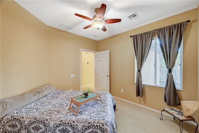 carpeted bedroom with a ceiling fan, visible vents, and baseboards