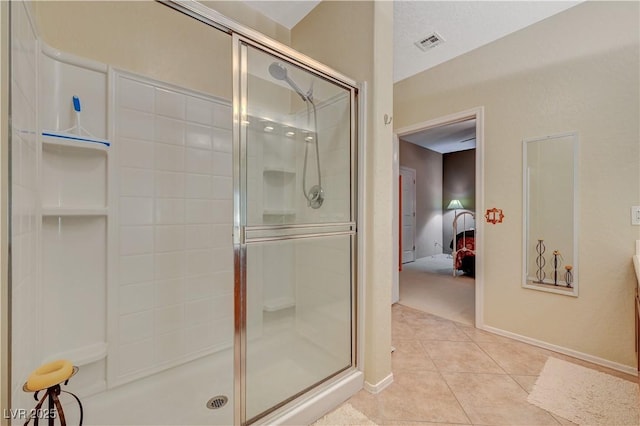 full bathroom with a stall shower, tile patterned flooring, visible vents, and baseboards