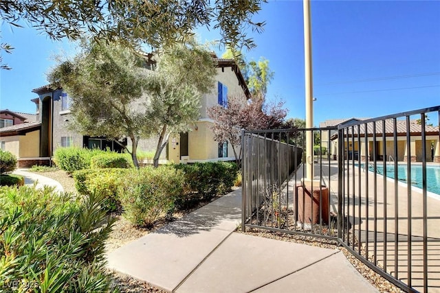 view of gate featuring fence and a fenced in pool