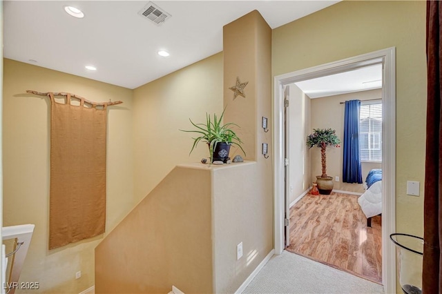 hall with baseboards, carpet flooring, visible vents, and recessed lighting