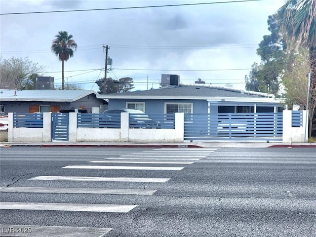 view of property with central air condition unit and fence