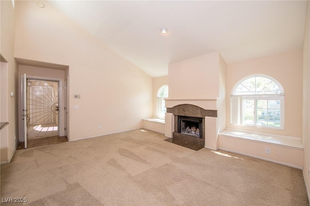 unfurnished living room featuring a fireplace with flush hearth, baseboards, carpet flooring, and a healthy amount of sunlight