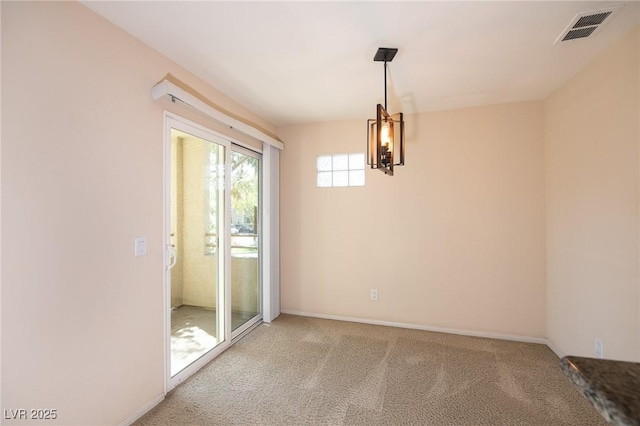 carpeted empty room with visible vents and baseboards