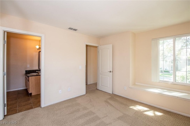 unfurnished bedroom with baseboards, visible vents, and carpet flooring