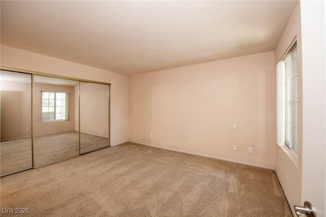 unfurnished bedroom with a closet, carpet flooring, and baseboards