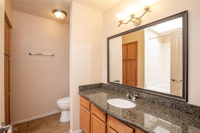 bathroom featuring baseboards, vanity, toilet, and tile patterned floors