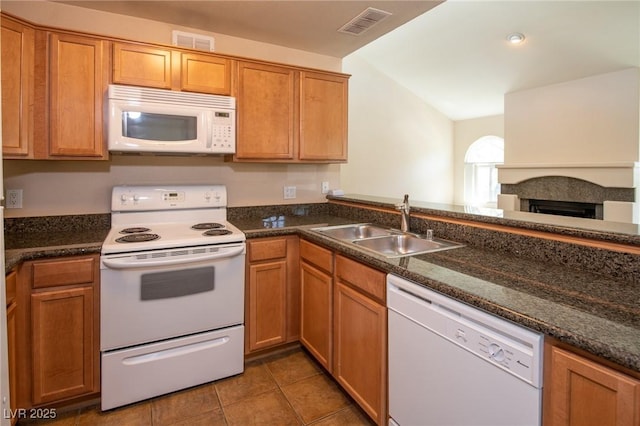 kitchen featuring white appliances, light tile patterned flooring, a sink, and visible vents