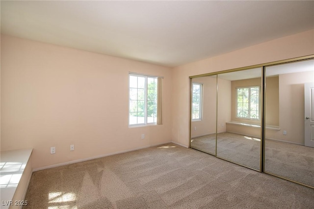 unfurnished bedroom featuring carpet floors, a closet, and baseboards