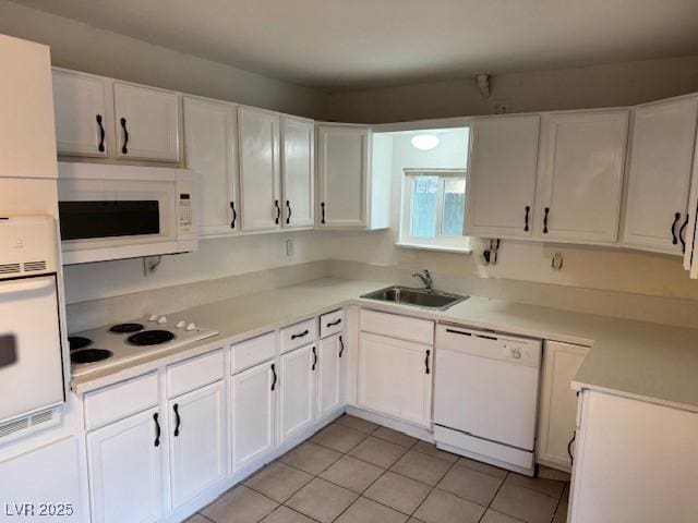 kitchen with light countertops, white appliances, white cabinetry, and a sink