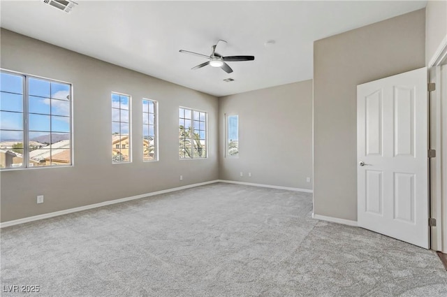 spare room featuring visible vents, carpet flooring, a ceiling fan, and baseboards