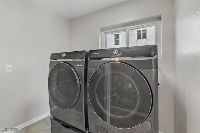 washroom featuring baseboards, laundry area, light tile patterned floors, and washer and dryer