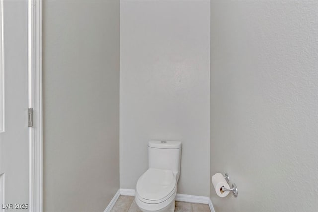 bathroom with tile patterned flooring, baseboards, and toilet