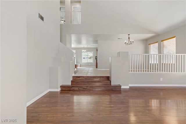 interior space with visible vents, a chandelier, and wood finished floors