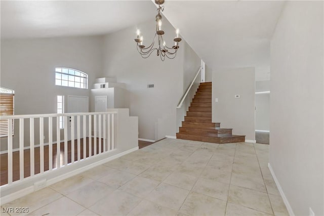 tiled foyer with an inviting chandelier, visible vents, stairs, and baseboards