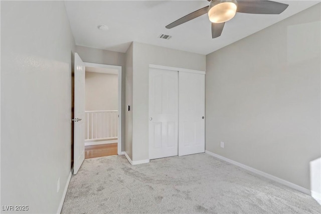 unfurnished bedroom with a closet, carpet, visible vents, and baseboards