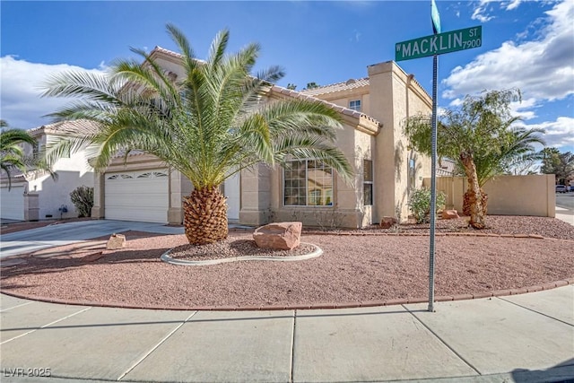 view of front of property featuring an attached garage, a tile roof, concrete driveway, and stucco siding