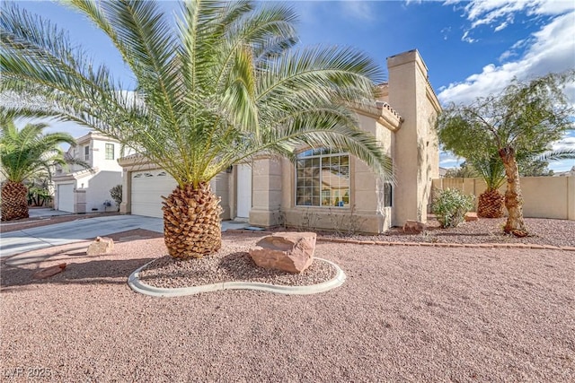 view of front of house featuring a garage, fence, concrete driveway, and stucco siding