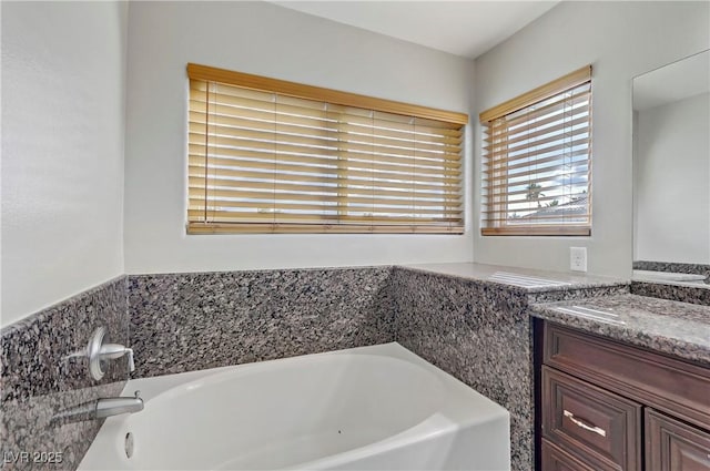 full bathroom with vanity and a bath