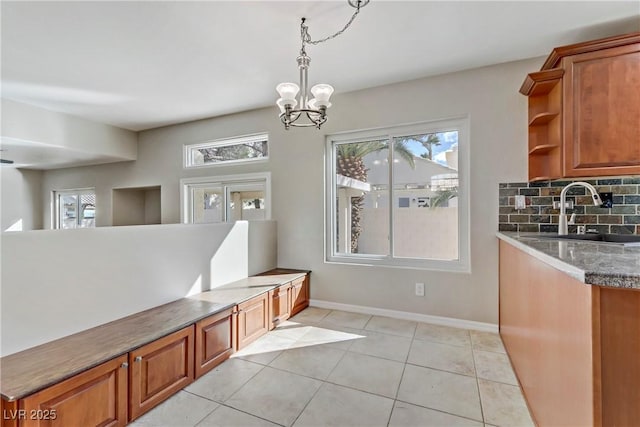 mudroom featuring light tile patterned floors, a notable chandelier, baseboards, and a sink