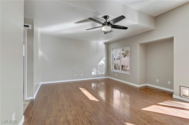 unfurnished room featuring wood finished floors, a ceiling fan, and baseboards