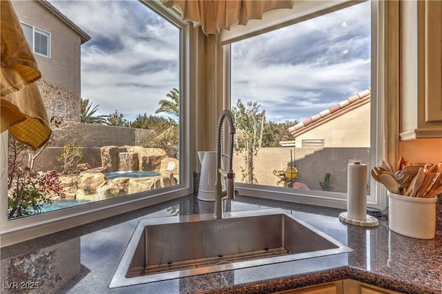 interior details with visible vents, a sink, and dark stone countertops