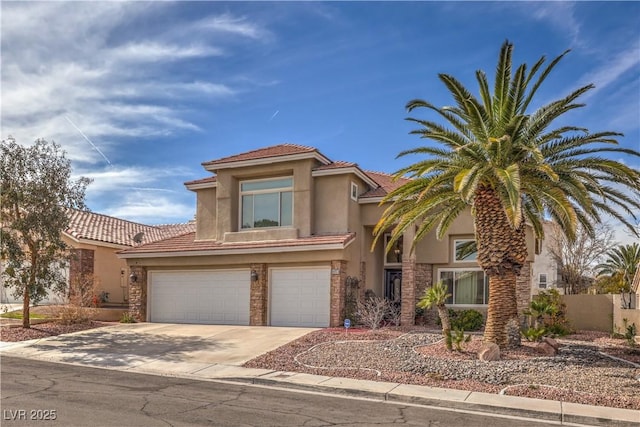 mediterranean / spanish home with a garage, a tile roof, driveway, and stucco siding