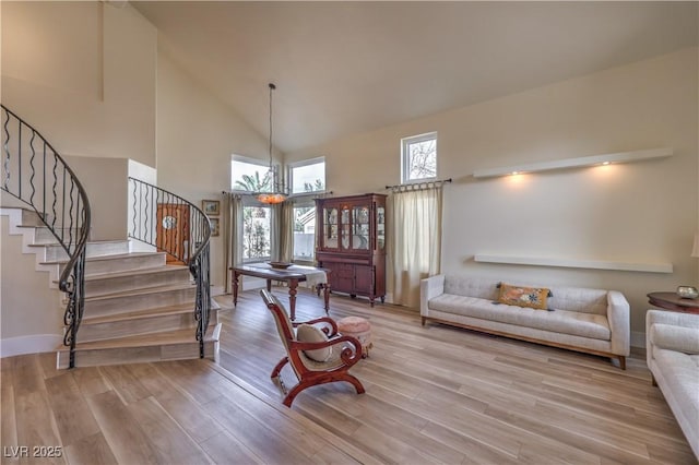 living area with light wood-style floors, plenty of natural light, and stairs