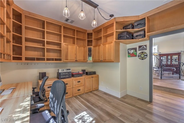 office featuring light wood-style floors, visible vents, baseboards, and built in study area