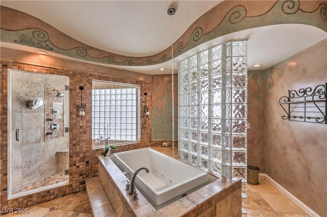 bathroom featuring a stall shower, baseboards, and a whirlpool tub