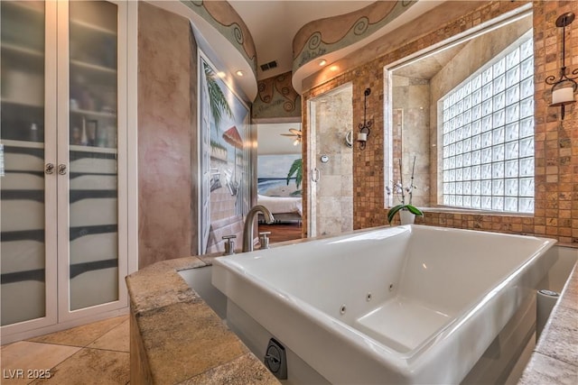 ensuite bathroom featuring ensuite bathroom, a soaking tub, visible vents, and tile patterned floors