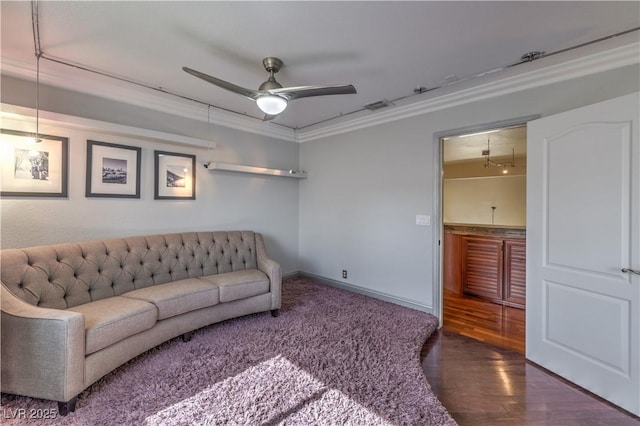 living area featuring baseboards, visible vents, ceiling fan, wood finished floors, and crown molding