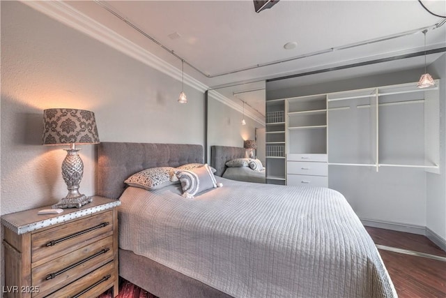 bedroom featuring ornamental molding, dark wood-type flooring, and baseboards