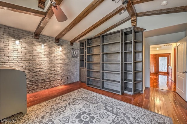 interior space with ceiling fan, vaulted ceiling with beams, and hardwood / wood-style flooring